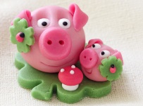 Marzipan pig with cloverleaf and mushroom on white